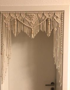 an open door with some tassels hanging from it's sides and a handle on the door