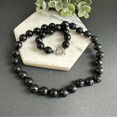 This Stunning Piece Is Hand Knotted And Features Faceted Natural Stones That Catch The Light Beautifully. The Black Onyx Beads Are Sleek And Sophisticated, Making This Necklace Perfect For Dressing Up Any Outfit. Whether You're Heading To A Fancy Event Or Just Want To Add Some Glam To Your Everyday Look, This Necklace Is Sure To Do The Trick. So Why Wait? Treat Yourself To This Gorgeous Piece Today! 10mm Faceted Black Onyx. Stainless Steel Sailor Clasp, Removable Pendant Can Be Added. Black Onyx Necklace With Gemstone Beads, Black Onyx Necklaces With Faceted Beads, Black Onyx Necklace With Faceted Beads, Black Faceted Round Necklace, Black Obsidian Necklace With Natural Stones, Black Onyx Round Bead Necklace, Classic Single Strand Onyx Necklace, Elegant Black Round Bead Crystal Necklaces, Classic Onyx Single Strand Necklace