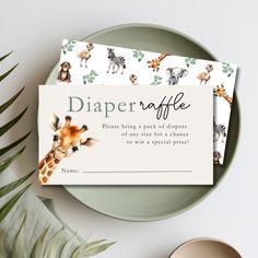 a baby giraffe diaper raf card on a plate next to a plant