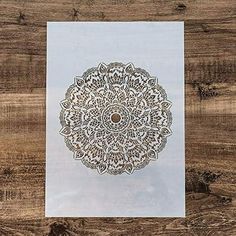 a white paper with an intricate design on it sitting on top of a wooden table