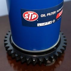 a blue oil filter sitting on top of a wooden table next to a black sprock