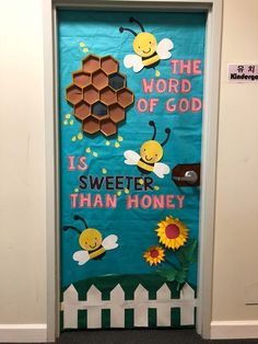 a door decorated with bees and honeycombs that says the word of god is sweeter than honey