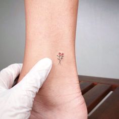 a person with a small flower tattoo on their ankle