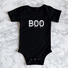 Nothing too spooky about this adorable Halloween onesie, perfect for your October babe. Matches the adult "Bad & Boozy" T-shirt. Comes in Black or White. Recommended Care Instructions Machine wash delicate cycle, cold/warm, inside out with like colors. Remove immediately after washing. Tumble dry on low or hang dry. Do not iron decal. Do not dry clean. Playful Black Short Sleeve Onesie, Unisex Black Short Sleeve Bodysuit, Black Short Sleeve Onesie With Letter Print, Playful Fitted Black Onesie, Cute Black Short Sleeve Onesie, Black Fitted Playful Onesie, Cute Black Cotton Bodysuit, Black Fitted Short Sleeve Onesie, Funny Fitted Black Onesie