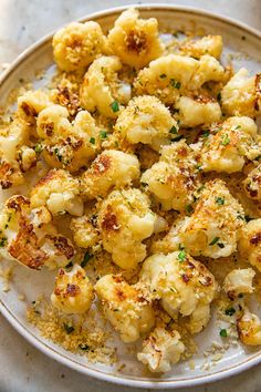 a white plate topped with cauliflower covered in seasoning