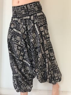 "These super soft rayon baggy unisex harem pants have the \"flow\", perfect of yoga or just a cool strolling. Comfort and character are what these pants are all about. They have the traditional sarong look & feel but a lot more practical when it comes to activity like yoga. As a bonus, they are convertible! Just pull them up and you get yourself a cute jumpsuit in a flash. Together with elastic cuff legs, you can wear them short or long. The pants have smock waist (wide bang elastic) with no Black Baggy Harem Pants For The Beach, Casual Harem Yoga Pants For Festival, Black Relaxed Fit Harem Pants For Beach, Casual Harem Bottoms For Meditation, Bohemian Black Harem Pants For Beach, Black Harem Beach Pants, Bohemian Drop Crotch Yoga Pants, Bohemian Yoga Pants With Drop Crotch, Casual Drop Crotch Harem Pants For Festivals