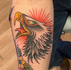 an eagle tattoo on the arm with flowers