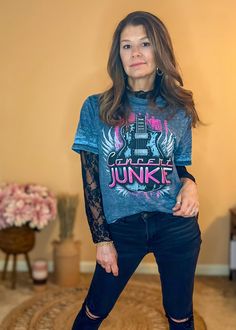 Get ready for a rocking summer with the Concert Junkie Graphic Tee! This vintage acid wash Colortone tee features a professional sublimated screen print with hot pink detailing and a guitar design. Perfect for festival season, this classic combo of 60% cotton and 40% polyester will keep you comfortable all day. Classic unisex fit Crew neckline Guitar with wings graphic Concert Junkie lettering Material: 60% cotton, 40% polyester Color: Blue Acid Wash Rocker Graphic Print Tops For Spring, Rocker Style Tops For Spring Concerts, Acid Wash Band Merch Tops For Music Festival, Rock Style Short Sleeve T-shirt For Spring, Acid Wash Graphic Tee For Concerts, Festival Acid Wash Graphic Tee Tops, Rock Style Graphic Print T-shirt For Spring, Rock Style Crew Neck T-shirt For Spring, Summer Acid Wash T-shirt For Concerts