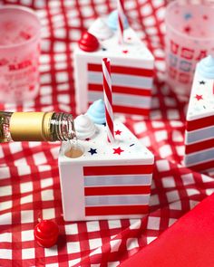 red and white checkered table cloth with small boxes filled with candy, straws and bottles