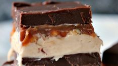 three pieces of ice cream and caramel brownie on a white plate with chocolate