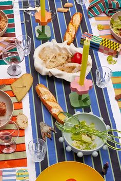 the table is set with colorful plates and bowls