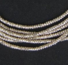 PRICES MAY VARY. Handmade by independent artisans in Ethiopia Each bead measures 1 x 2mm diameter, with hole size of 1mm Sold by the strand - wholesale value 100% Authentic Ethiopian product Official product of The Bead Chest Take a look at this great strand of Silver beads fashioned in a heishi shape. Each strand is 30" long with approximately 450+ beads measuring 1 x 2mm diameter. These great beads are highly versatile and may be used as spacers or accents in your unique designs. A great addit Blue Green Gold, Ethnic Necklaces, Dog Jewelry, African Beads, Trade Beads, Heishi Beads, Bead Shop, Creative Jewelry, Shell Beads