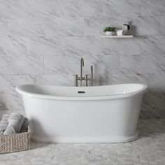 a white bath tub sitting in a bathroom next to a shelf with towels on it