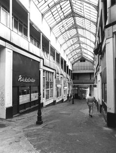 an empty shopping mall with people walking around