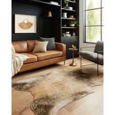 a living room with a couch, chair and bookcase in black wall paint color