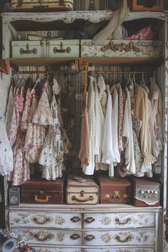 an old dresser with clothes and suitcases hanging on it's shelves in a closet