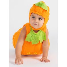 a baby dressed in an orange pumpkin costume