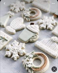 some cookies are sitting on a table with snowflakes and wreaths around them