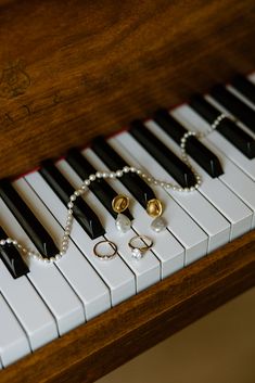 a close up of a piano with pearls and rings on it's strings,