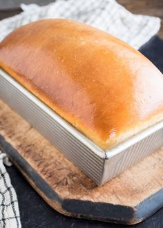 a loaf of bread sitting on top of a wooden cutting board