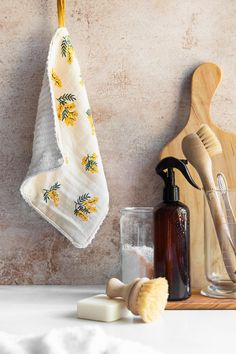 a towel hanging on a hook next to a bottle and soap dispenser