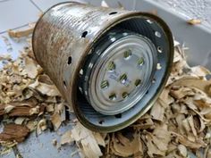 an old metal can sitting on top of wood shavings