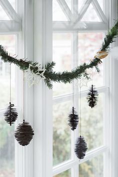 pine cones are hanging from the window sill