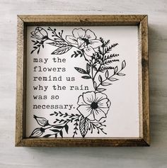 a wooden frame with flowers on it and a quote in the middle that reads, may the flowers remind us why the rain was so necessary