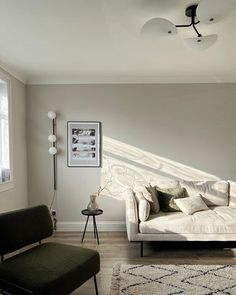 a living room filled with furniture and a white rug on top of a hard wood floor