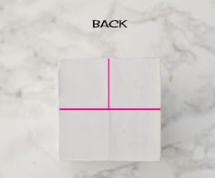 a white box sitting on top of a marble counter next to a pink line that says back