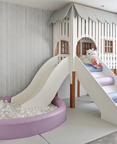 a child's play area with a slide and ball pit