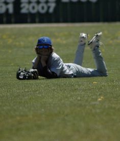 a person laying on the ground with a baseball glove