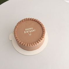 a birthday cake with the words happy birthday on it sitting on a white tablecloth