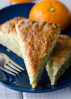 two slices of pie on a blue plate with an orange in the backgroud