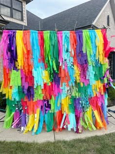 colorful streamers hanging from clothes line in front of house