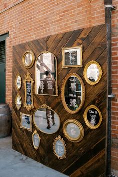 a wooden wall with many mirrors and plaques on it's side, along with wine barrels