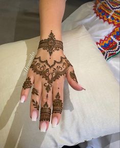 a woman's hand with henna tattoos on it