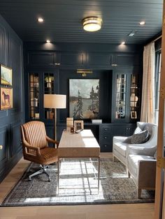 a living room filled with furniture and a painting on the wall above it's fireplace