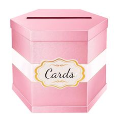 a pink box with a white stripe around the bottom and a gold border around the top that says cards