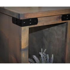 a close up of a wooden shelf with some plants in it