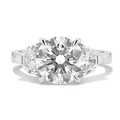 a three stone diamond ring on a white background