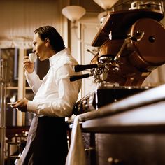 a man standing in a kitchen drinking from a cup