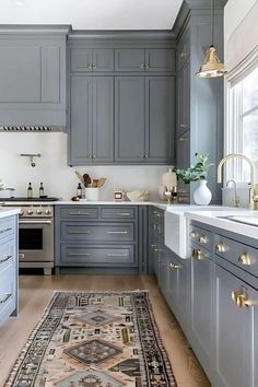 a kitchen with gray cabinets and rug in the middle