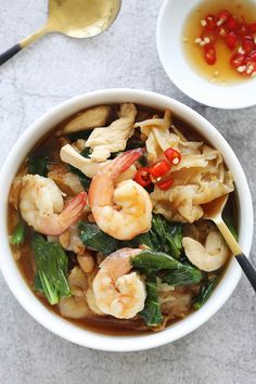 a white bowl filled with shrimp and noodles