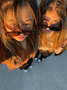 two girls with sunglasses are looking up at the camera