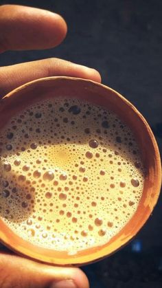 a person holding a cup with some liquid in it