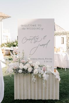 a welcome sign is set up on the lawn for guests to arrive at their wedding