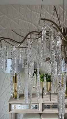 a chandelier hanging from the ceiling in a room with mirrors and vases