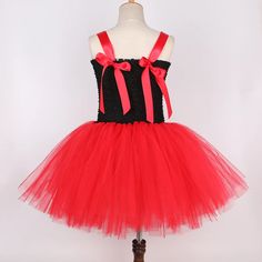 a red and black dress on a mannequin headdress with pink bows