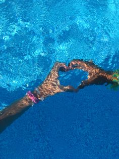 a man swimming in a pool with his arm wrapped around the edge of the water